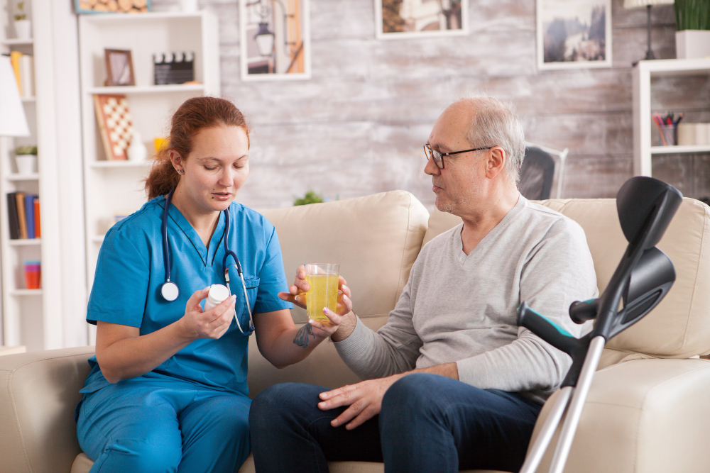 Home health aide providing medication assistance to an older man receiving home care in Cincinnati, OH
